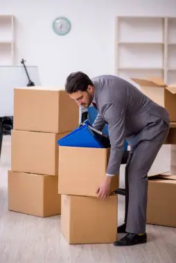 Movers loading furniture onto a truck for office relocation